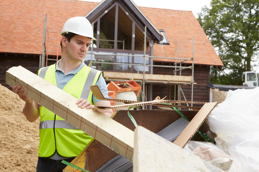 Builder Putting Waste Into Rubbish Skip